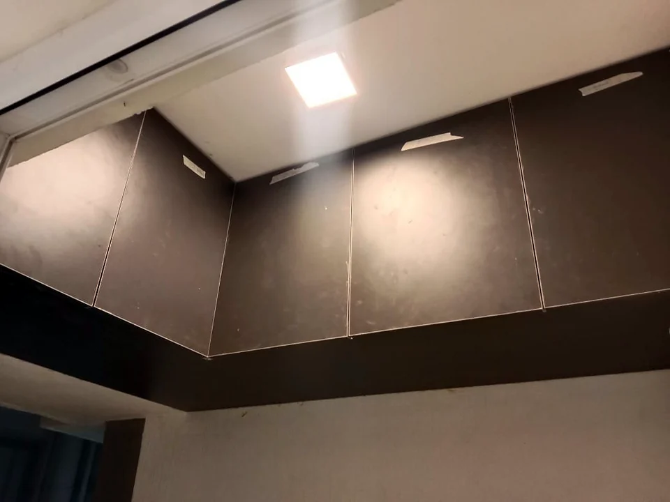Dark panelled false ceiling and wall cladding with recessed lighting by Wood Crops, Chennai