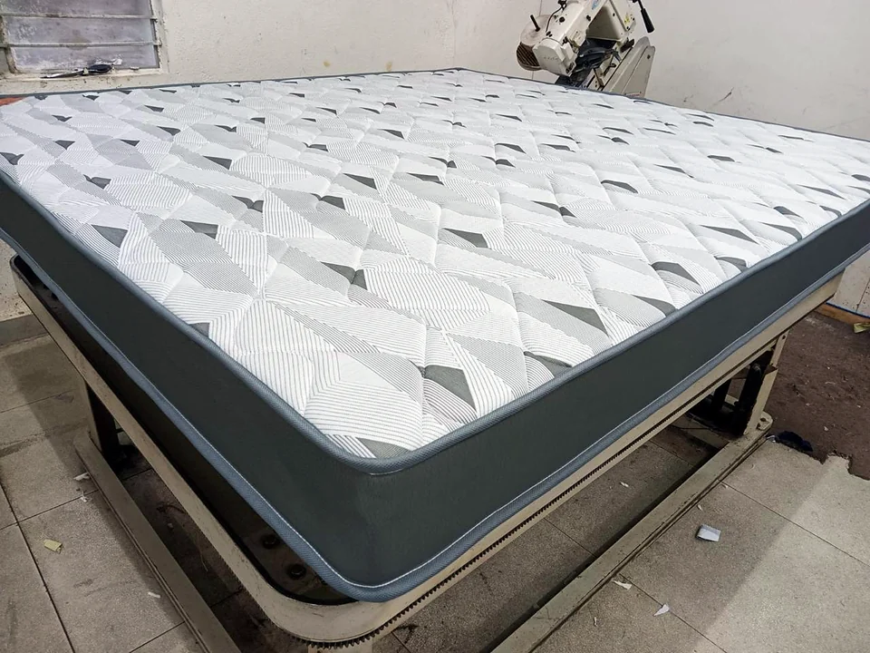 Quilted mattress with grey border on the tape-edge machine at the Wood Crops factory, Chennai