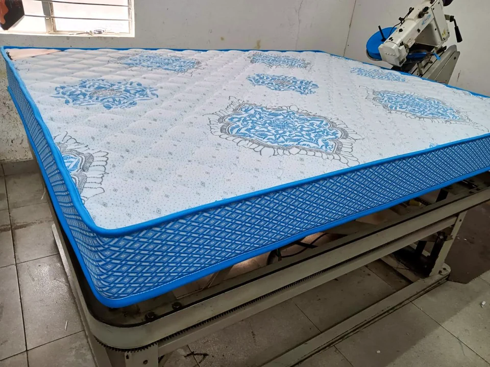 Quilted mattress with blue border on the stitching table at the Wood Crops factory, Chennai